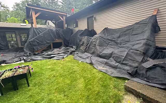 lp-landscape-house-protection tarps protecting landscaping and shrubs while H and S Roofing completes a roofing project